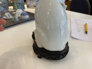 Een Chinees blanc de Chine model van een kat op houten sokkel, Republiek