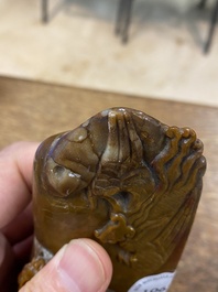 Een Chinese bruine jade zegelstempel met inscriptie en een witte jade sculptuur van een berglandschap, 19/20e eeuw