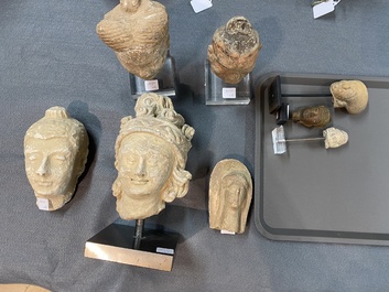 Acht diverse gesculpteerde stenen hoofden, o.a. Gandhara, Etruskisch, Japans en Chinees