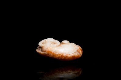 Een Chinese witte en roestkleurige jade hanger in de vorm van een buffel, 19e eeuw