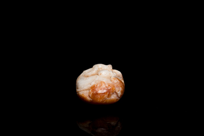 Een Chinese witte en roestkleurige jade hanger in de vorm van een buffel, 19e eeuw