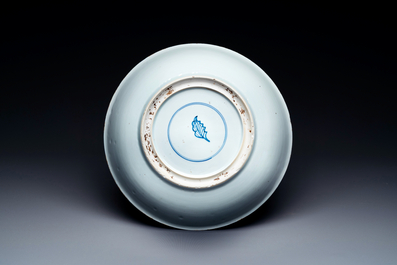 A Chinese famille verte dish with a lady in a garden and a boy offering her a 'jue' vessel, Kangxi