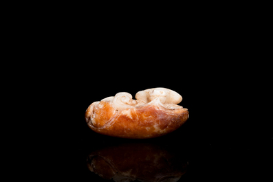 Een Chinese witte en roestkleurige jade hanger in de vorm van een buffel, 19e eeuw
