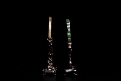 Un disque 'bi' en jade c&eacute;ladon et rouille et un pendentif en forme de fleur en jade vert sur socles en bois, Ming et Qing