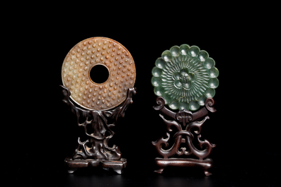 Un disque 'bi' en jade c&eacute;ladon et rouille et un pendentif en forme de fleur en jade vert sur socles en bois, Ming et Qing