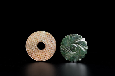 Un disque 'bi' en jade c&eacute;ladon et rouille et un pendentif en forme de fleur en jade vert sur socles en bois, Ming et Qing