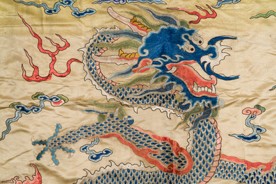 A large Chinese yellow-ground silk embroidery decorated with three five-clawed dragons, 19th C.