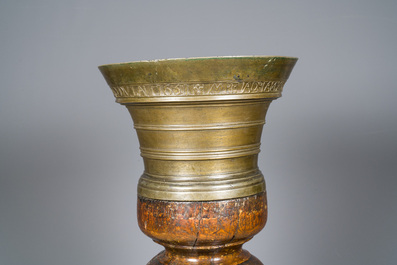 A large French bronze mortar and pestle on its carved oak base, dated 1631