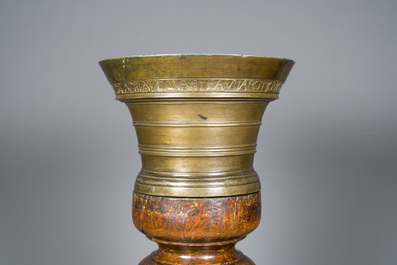 A large French bronze mortar and pestle on its carved oak base, dated 1631