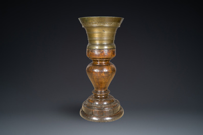 A large French bronze mortar and pestle on its carved oak base, dated 1631