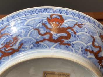Een paar Chinese schotels met ijzerrood drakendecor op blauw-witte golven, Qianlong merk en periode