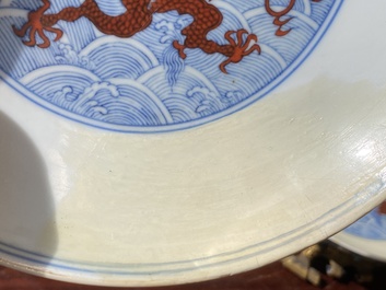 Een paar Chinese schotels met ijzerrood drakendecor op blauw-witte golven, Qianlong merk en periode