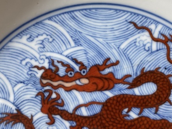Een paar Chinese schotels met ijzerrood drakendecor op blauw-witte golven, Qianlong merk en periode