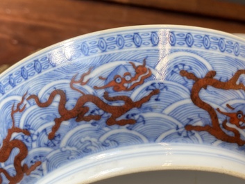 Een paar Chinese schotels met ijzerrood drakendecor op blauw-witte golven, Qianlong merk en periode