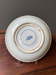 A Chinese famille verte dish with a lady in a garden and a boy offering her a 'jue' vessel, Kangxi