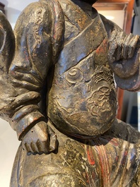 A Chinese lacquered and polychromed wood sculpture of a Buddhist guardian, Ming