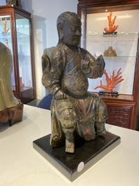 A Chinese lacquered and polychromed wood sculpture of a Buddhist guardian, Ming