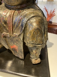 A Chinese lacquered and polychromed wood sculpture of a Buddhist guardian, Ming