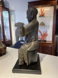 A Chinese lacquered and polychromed wood sculpture of a Buddhist guardian, Ming