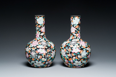 Paire de vases de forme bouteille en porcelaine de Chine famille rose &agrave; d&eacute;cor millefleurs sur fond noire, marque de Qianlong, R&eacute;publique