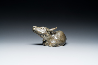 Een Chinese monochrome sculptuur van een liggende waterbuffel op houten sokkel, 19e eeuw