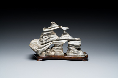 A Chinese grey lingbi stone scholar's rock on wooden stand, 19/20th C.
