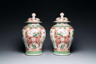 Een paar Chinese famille verte dekselvazen met decor van antiquiteiten, 19e eeuw