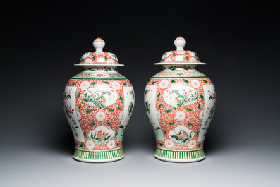 Een paar Chinese famille verte dekselvazen met decor van antiquiteiten, 19e eeuw