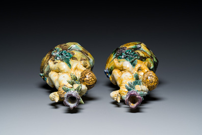 A pair of polychrome Talavera pottery candlesticks with putti on a branch, Spain, 18th C.