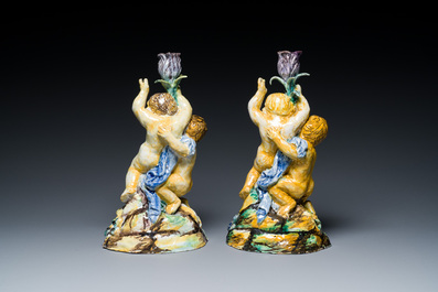A pair of polychrome Talavera pottery candlesticks with putti on a branch, Spain, 18th C.