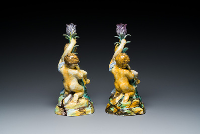A pair of polychrome Talavera pottery candlesticks with putti on a branch, Spain, 18th C.