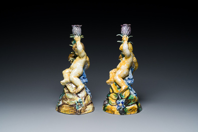 A pair of polychrome Talavera pottery candlesticks with putti on a branch, Spain, 18th C.