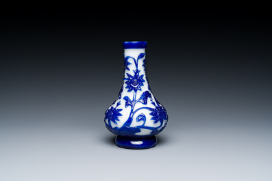 A Chinese overlay Beijing glass bottle vase with lotus scrolls in blue on white, 19th C.