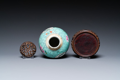 Een Chinese famille rose vaas met turquoise fondkleur met opengewerkt houten deksel en sokkel, 1e helft 19e eeuw