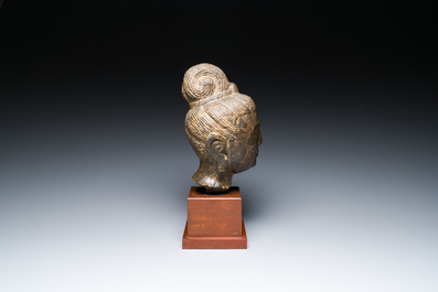 Een Chinees bruin-grijs kalkstenen hoofd van Bodhisattva, wellicht Tang
