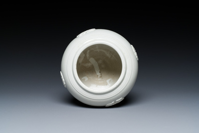 A Chinese white-glazed relief-molded bowl, Qianlong mark, 19th C.
