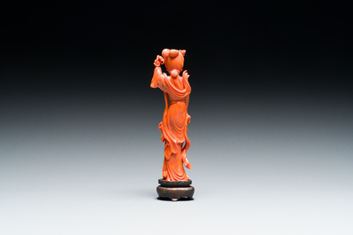 Een Chinese bloedkoralen sculptuur van een dame met een fruitmand, 19/20e eeuw