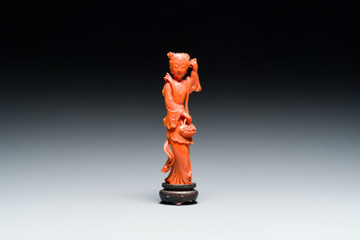 Een Chinese bloedkoralen sculptuur van een dame met een fruitmand, 19/20e eeuw