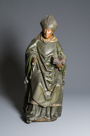 A large polychromed wood sculpture of a seated bishop, probably France, early 16th C.