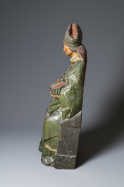A large polychromed wood sculpture of a seated bishop, probably France, early 16th C.