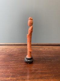Een Chinese bloedkoralen sculptuur van een staande dame met hofketting, 19/20e eeuw