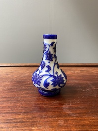 A Chinese overlay Beijing glass bottle vase with lotus scrolls in blue on white, 19th C.