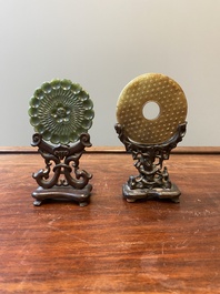 Un disque 'bi' en jade c&eacute;ladon et rouille et un pendentif en forme de fleur en jade vert sur socles en bois, Ming et Qing
