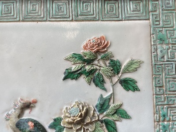A Chinese relief-decorated famille verte 'peacock' plaque in a fine carved hongmu wooden frame, 19th C.