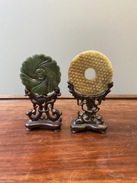 Un disque 'bi' en jade c&eacute;ladon et rouille et un pendentif en forme de fleur en jade vert sur socles en bois, Ming et Qing