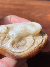 Een Chinese witte en roestkleurige jade hanger in de vorm van een buffel, 19e eeuw