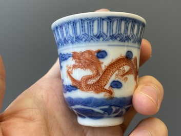 A Chinese blue, white and iron-red 'dragon' bowl and cover and a wine cup, Qianlong mark, 18/19th C.