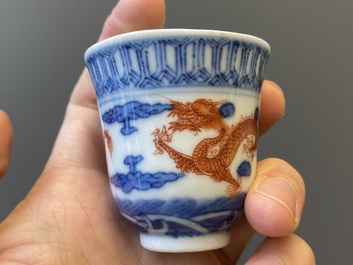 A Chinese blue, white and iron-red 'dragon' bowl and cover and a wine cup, Qianlong mark, 18/19th C.