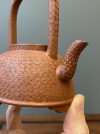 Een Chinese Yixing steengoed theepot met gekerfd decor van chrysanten, Kangxi