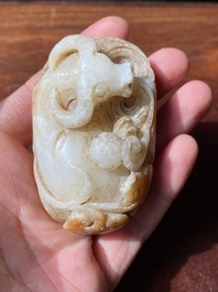 Een Chinese witte en roestkleurige jade hanger in de vorm van een buffel, 19e eeuw